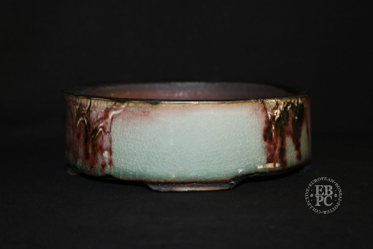 Eddie Curtis, England.   - 18.3cm; Hand-thrown; Round; Exceptional Glaze; Celadon; Blood-reds; Browns; Crackle Effect; Oxide Finished Feet; Stamped by the Artist.