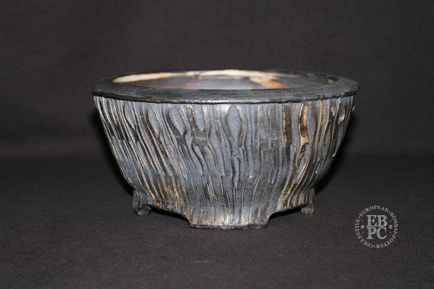 Eddie Curtis, England.   - 19cm; Hand-thrown; Round; Ribbon-like Texture; Gunmetal Grey; Browns; Glaze &amp; Oxide Finished; Foot Ring &amp; Feet; Stamped by the Artist.