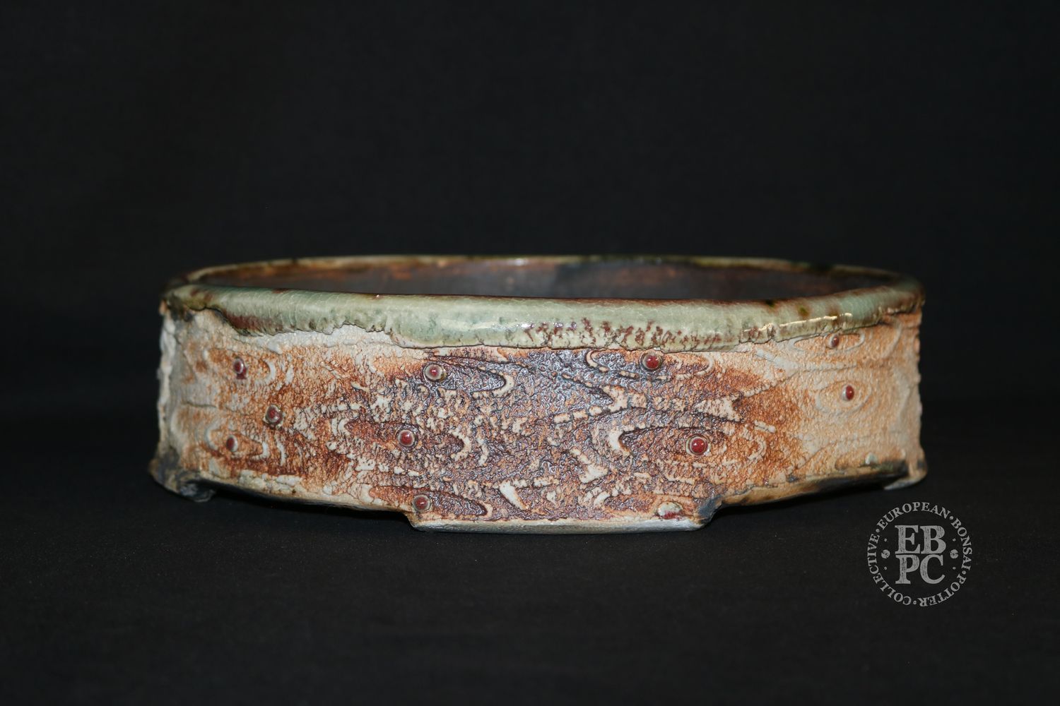 Eddie Curtis, England.   - 25.7cm; Oval; Unique Design; Part Glazed; Textured Relief Pattern; Celadon; Copper Red; Multiple Glaze Techniques; EBPC &amp; Artist Stamped;