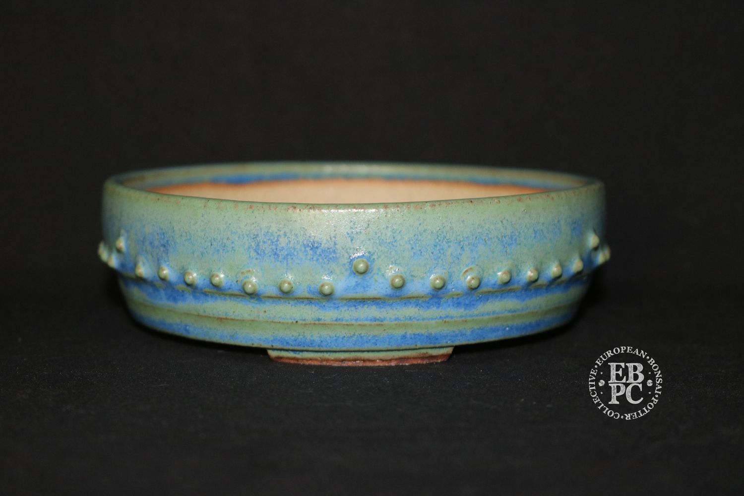 Ian Baillie - 13.3cm; Round; Drum Style; Superb Glaze; Rivets/Studs; Pastel Greens; Light Blues.      Made by Ian Baillie of Scotland.