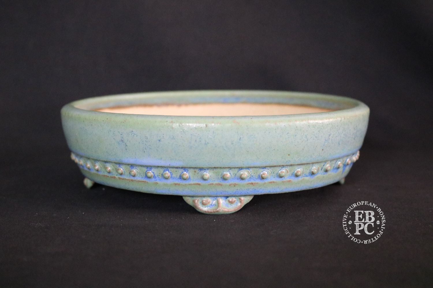 Ian Baillie - 18cm; Round; Drum Style; Superb Glaze; Rivets/Studs; Pastel Green; Light Blues; Brown.                                 Made by Ian Baillie of Scotland.