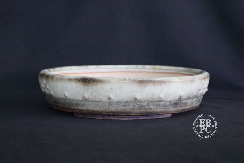 Ian Baillie - 26.7cm; Round; Drum Style; Superb Aged-looking Glaze; Rivets/Studs; Light Mint Green; Cream; Browns; Made by Ian Baillie of Scotland.