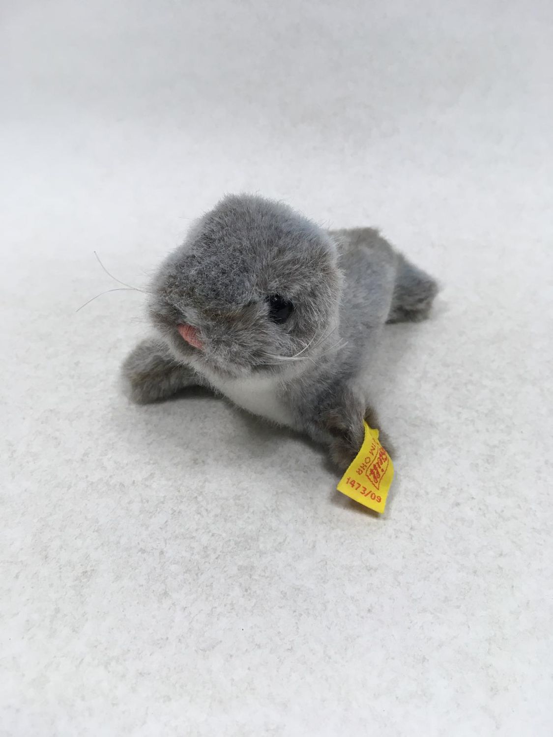 Steiff Robbe Olly 1473/09 mit Knopf und Fahne  liegend 17 cm selten