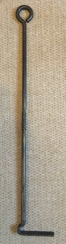 A hand forged fire poker rake with decorative square twist and eyelet holding hook.
