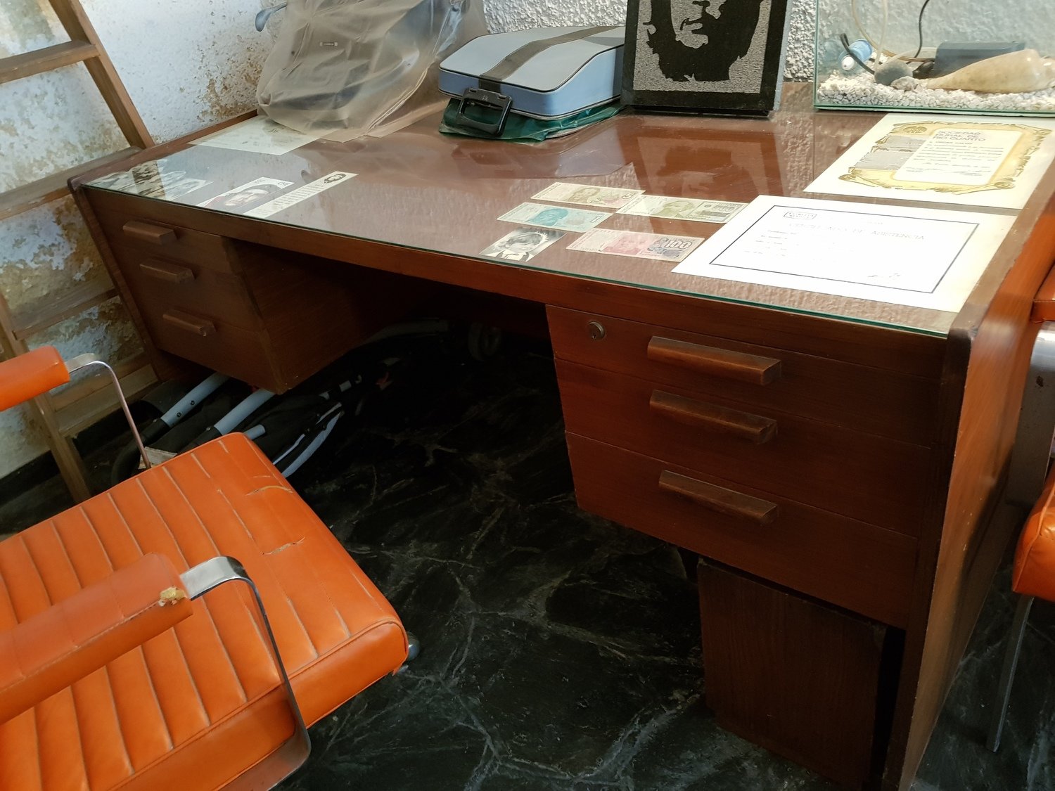 Escritorio antiguo, silla, sillones y biblioteca