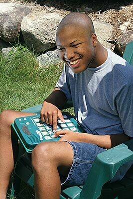 A boy using a GoTalk 20+ Lite Touch communication device.
