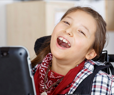 A smiling girl using a Tobii eye tracker.