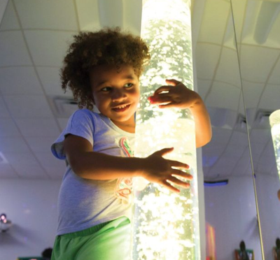 A girl hugs a Rompa Maxi bubble tube.