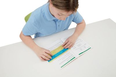 A child reading a book with the help of a screenruler