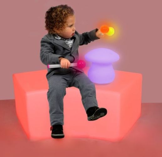 A child sitting on an red LED lit plastic bench