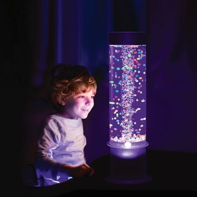 A child watching coloured balls in lit bubble tube