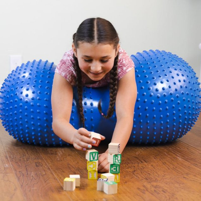 Image of child resting upper body on inflatable sensory roller in prone