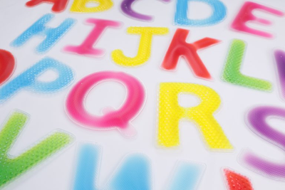Close up view of different coloured textured jelly alphabet letters in uppercase