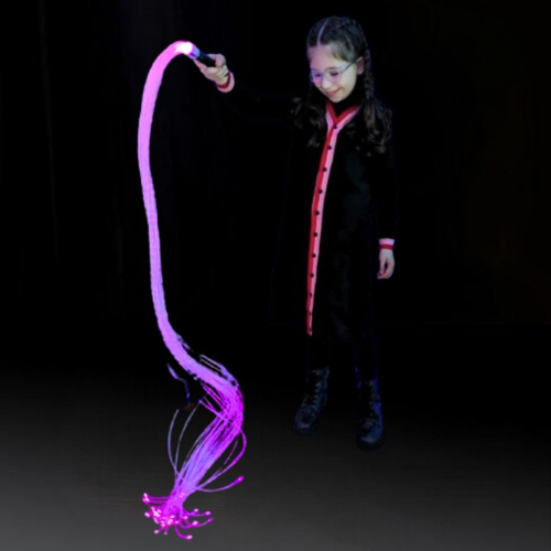 Image of a girl holding a handheld fibre optic wand with tails, lit in purple