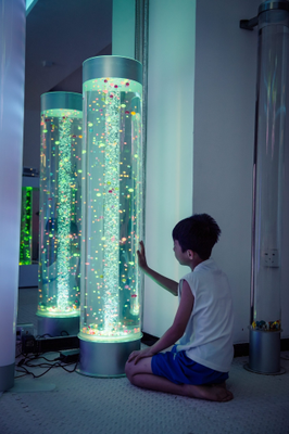 Image showing a child interacting with a extra wide bubble tube with floating balls in a darkened room