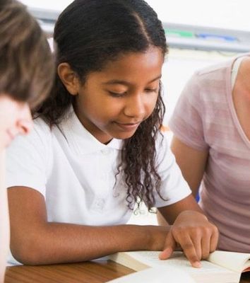 A girl looking down at the words she is reading. 