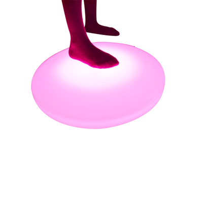 light up interactive floor tile lit up in pink as foot steps on it