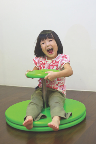 A girl sitting on a sit and spin