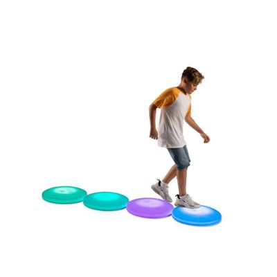 Image of boy stepping on multiple light up interactive floor tiles in a row