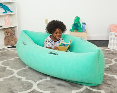 Image of child sitting in green inflatable canoe