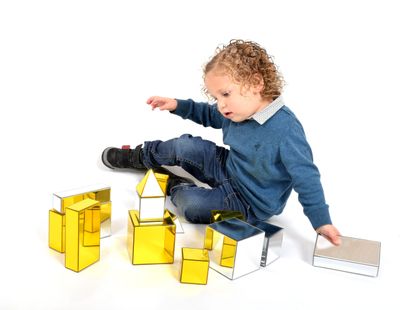 Image of child playing with metallic building blocks on the floor
