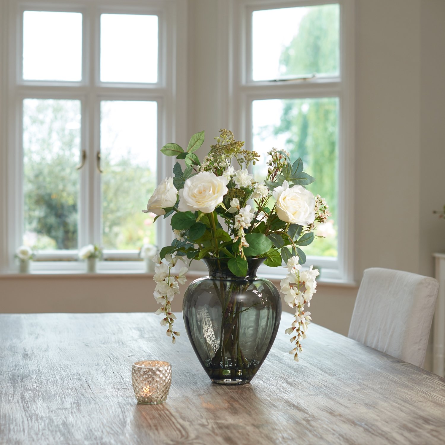 ROSES, WISTERIA AND FOLIAGE IN SMOKED OPTIC HEART VASE ROSES, WISTERIA AND FOLIAGE IN SMOKED OPTIC HEART VASE
