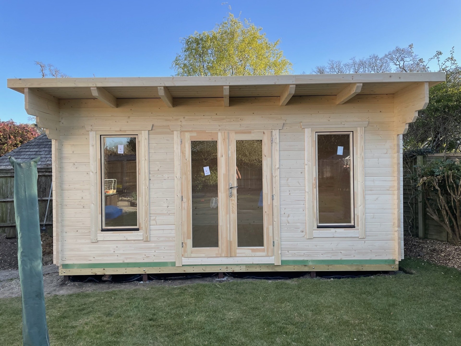 side view of green log cabin