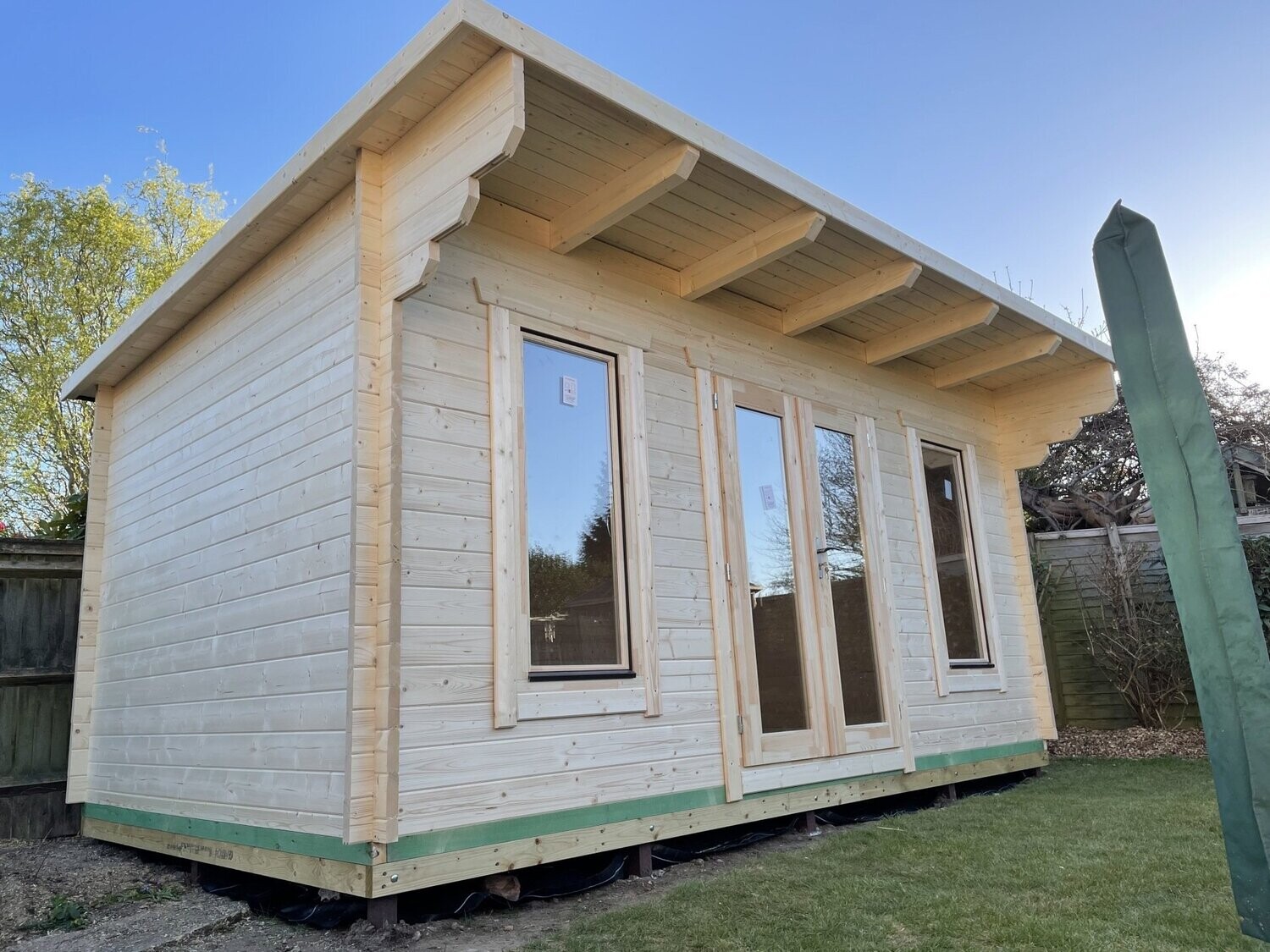 side view of green log cabin