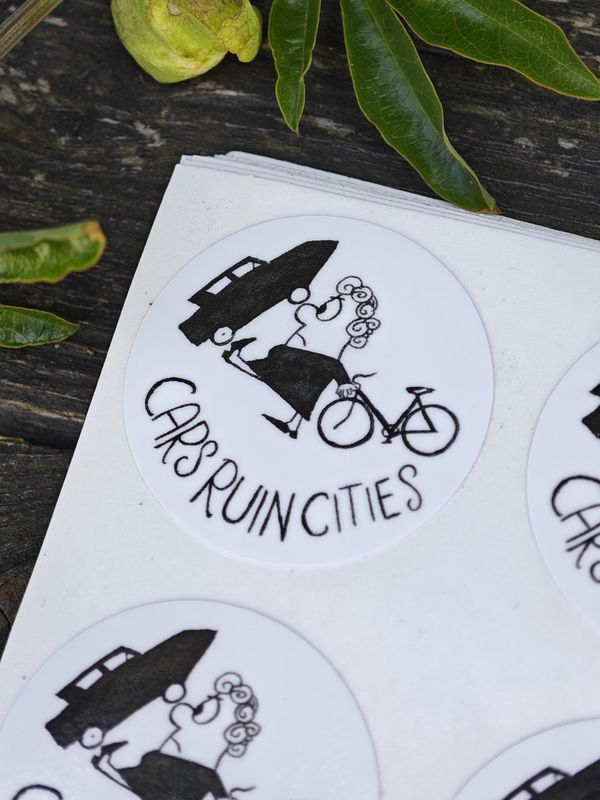 Sticker 34mm "cars ruin cities", lady cyclist kicks car...