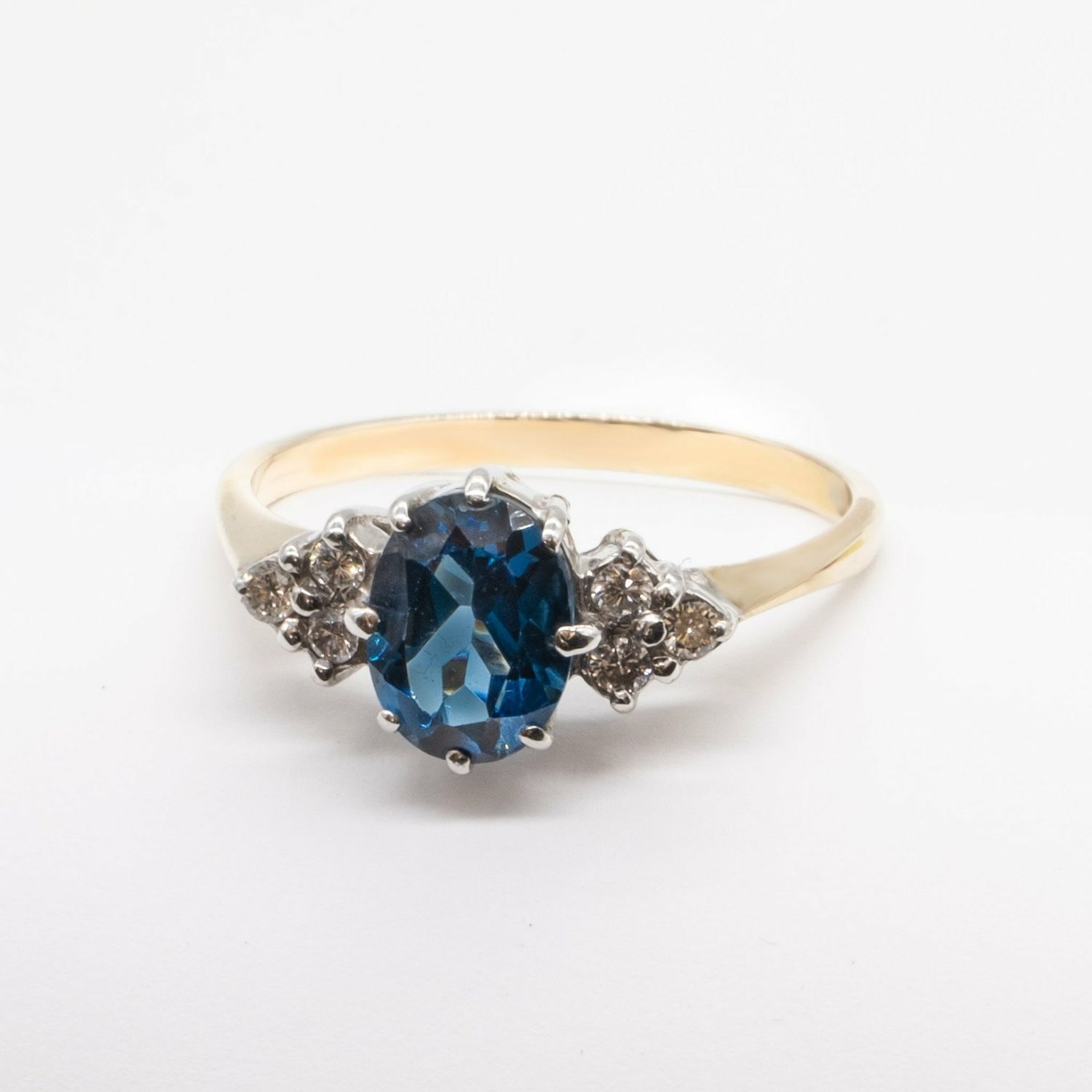 Oval blue topaz and 6 diamond ring in 9ct yellow gold