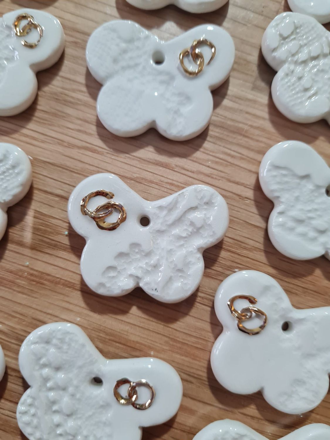 Farfalline in ceramica con fedi in oro in rilievo.