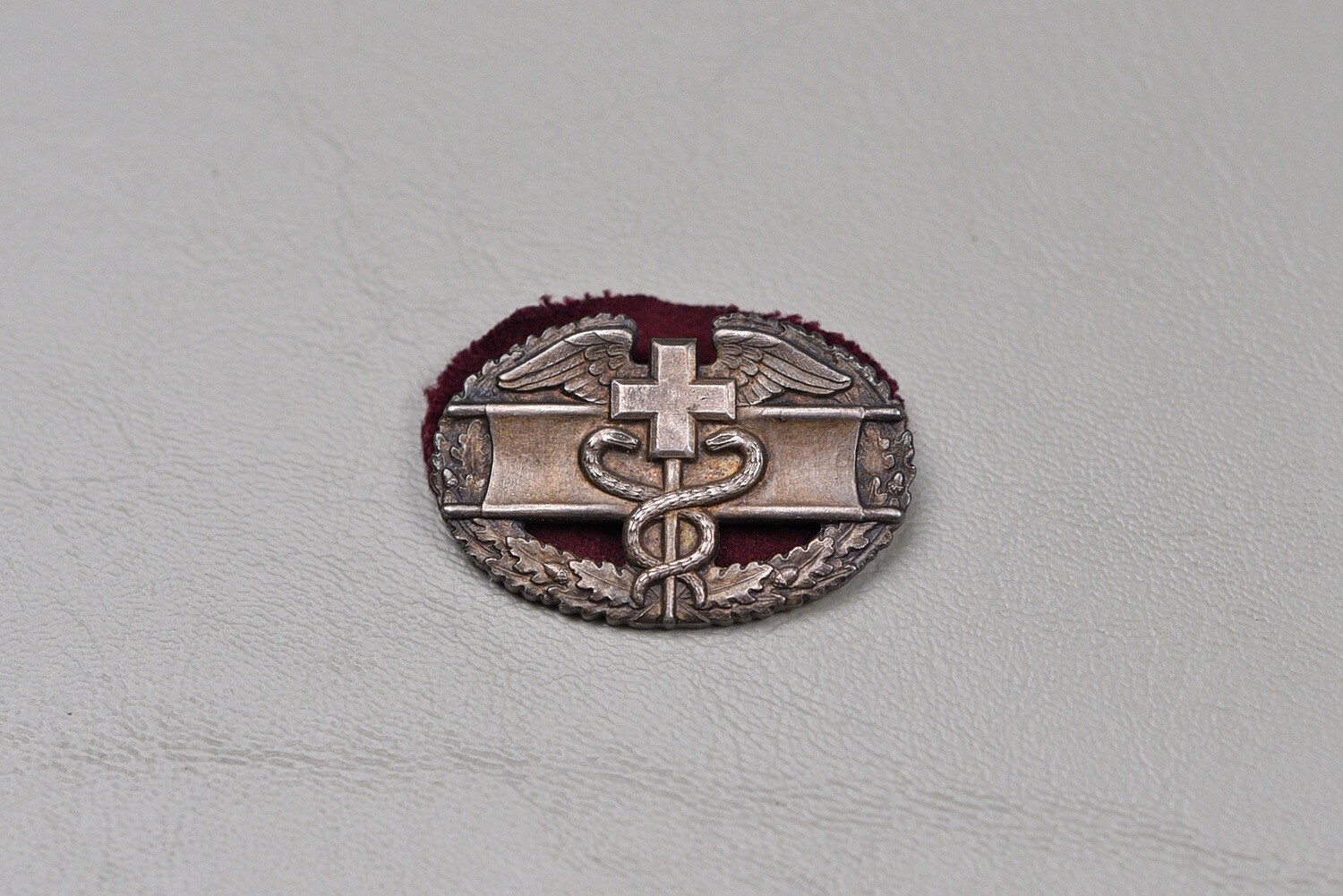 WWII U.S. COMBAT MEDIC BADGE w/MAROON OVAL BACKING