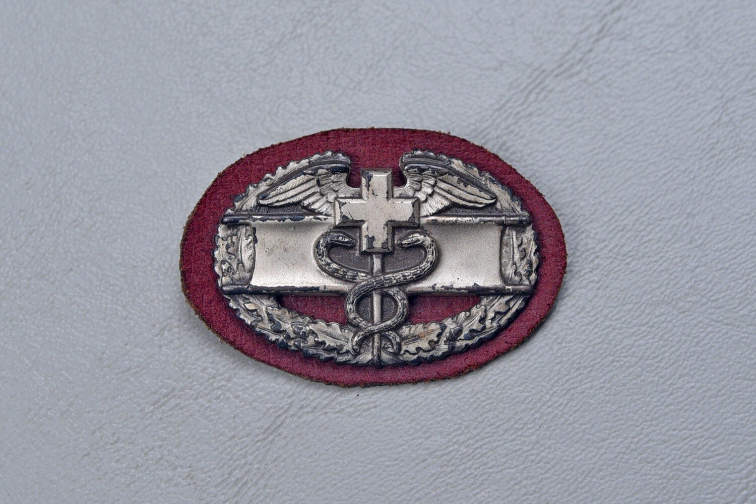 WWII U.S. COMBAT MEDIC BADGE ON MAROON BACKING - PIN BACK STERLING