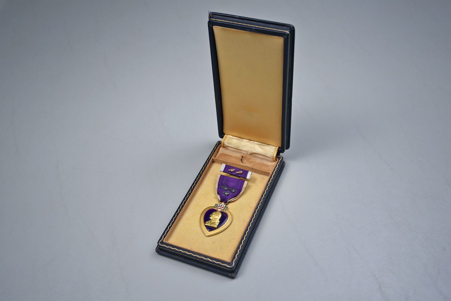 WWII U.S. PURPLE HEART MEDAL W/3 OAK LEAF CLUSTERS IN BLACK LEATHERETTE CASE
