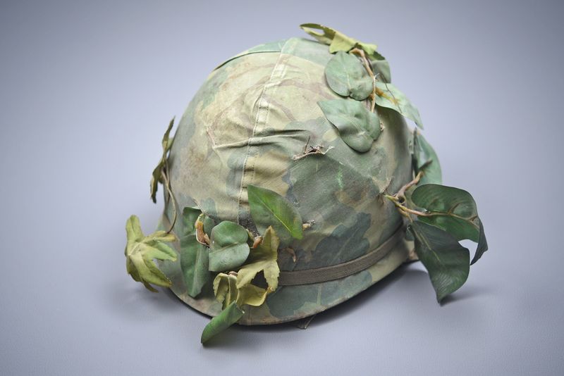 VIETNAM WAR U.S. M1 HELMET w/MITCHELL COVER & CAMO FOLIAGE – DATED ‘65’ VIETNAM WAR U.S. M1 HELMET w/MITCHELL COVER & CAMO FOLIAGE – DATED ‘65’