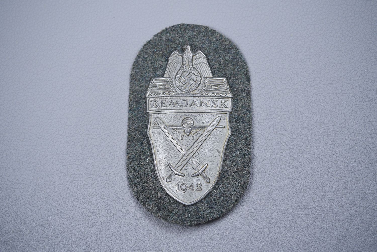 WWII GERMAN DEMJANSK SHIELD ON ARMY BACKGROUND WWII GERMAN DEMJANSK SHIELD ON ARMY BACKGROUND