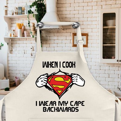 Apron: WHEN I COOK I WEAR MY CAPE BACKWARDS