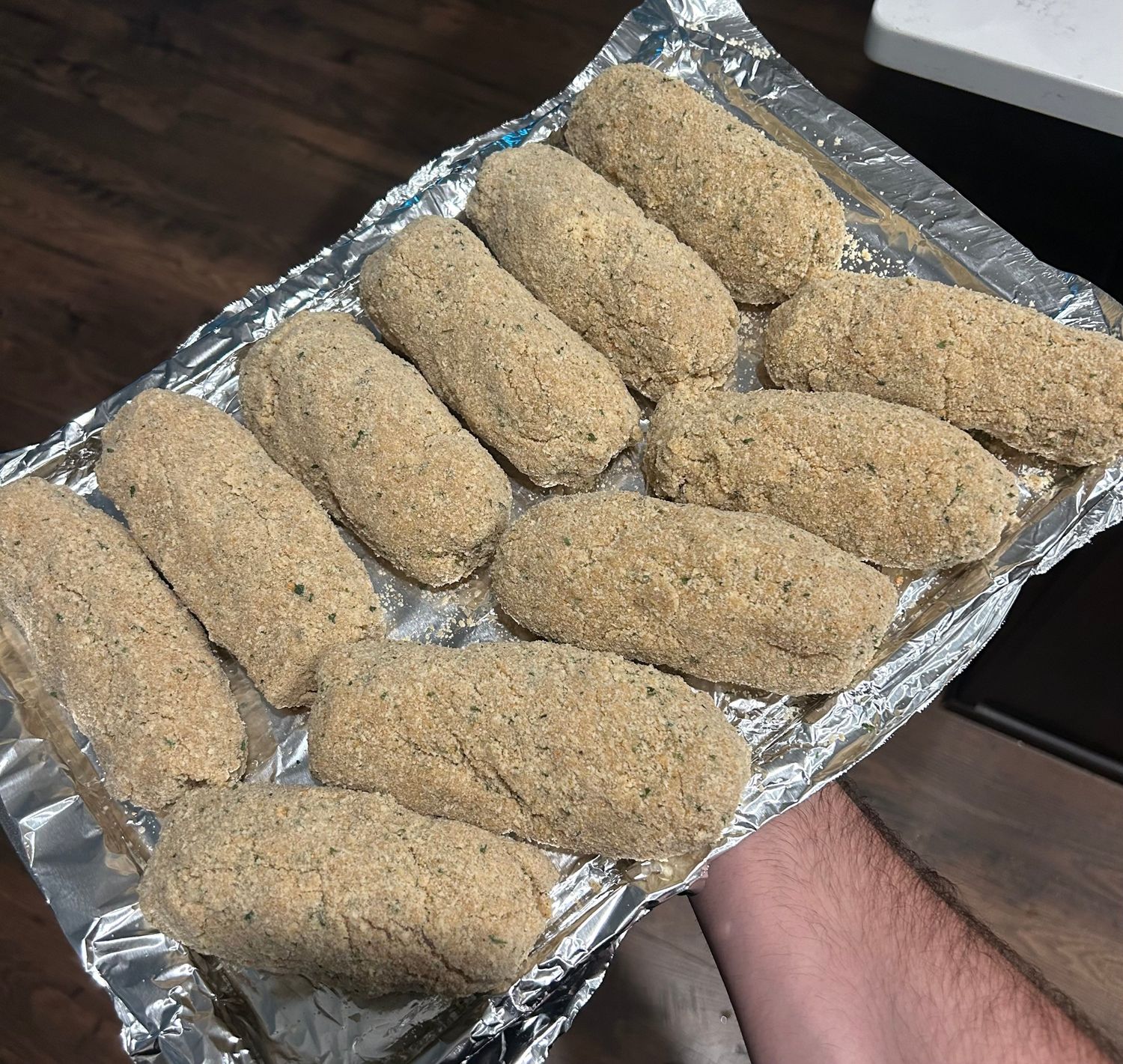 Hand breaded Chicken Rockefeller ready for the fryer