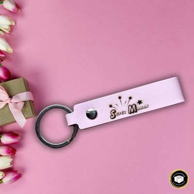 Porte-clés en cuir rose personnalisé avec le texte super maman. Disponible avec une pochette personnalisée.