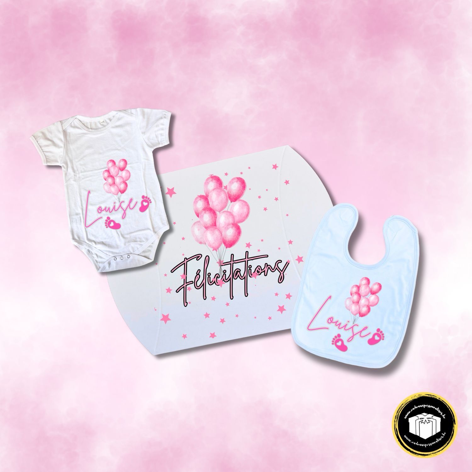 Coffret cadeau naissance rose avec une boîte cadeau, un body et un bavoir