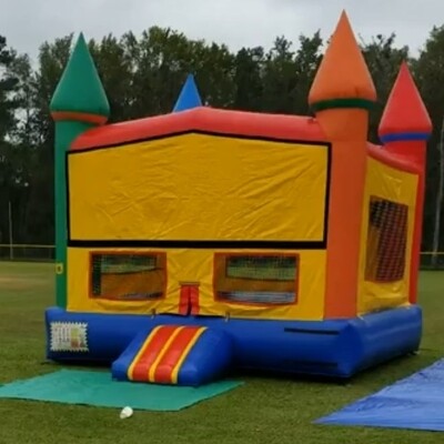Red yellow and blue 15 by 15 jumping castle with basketball hoop in it.