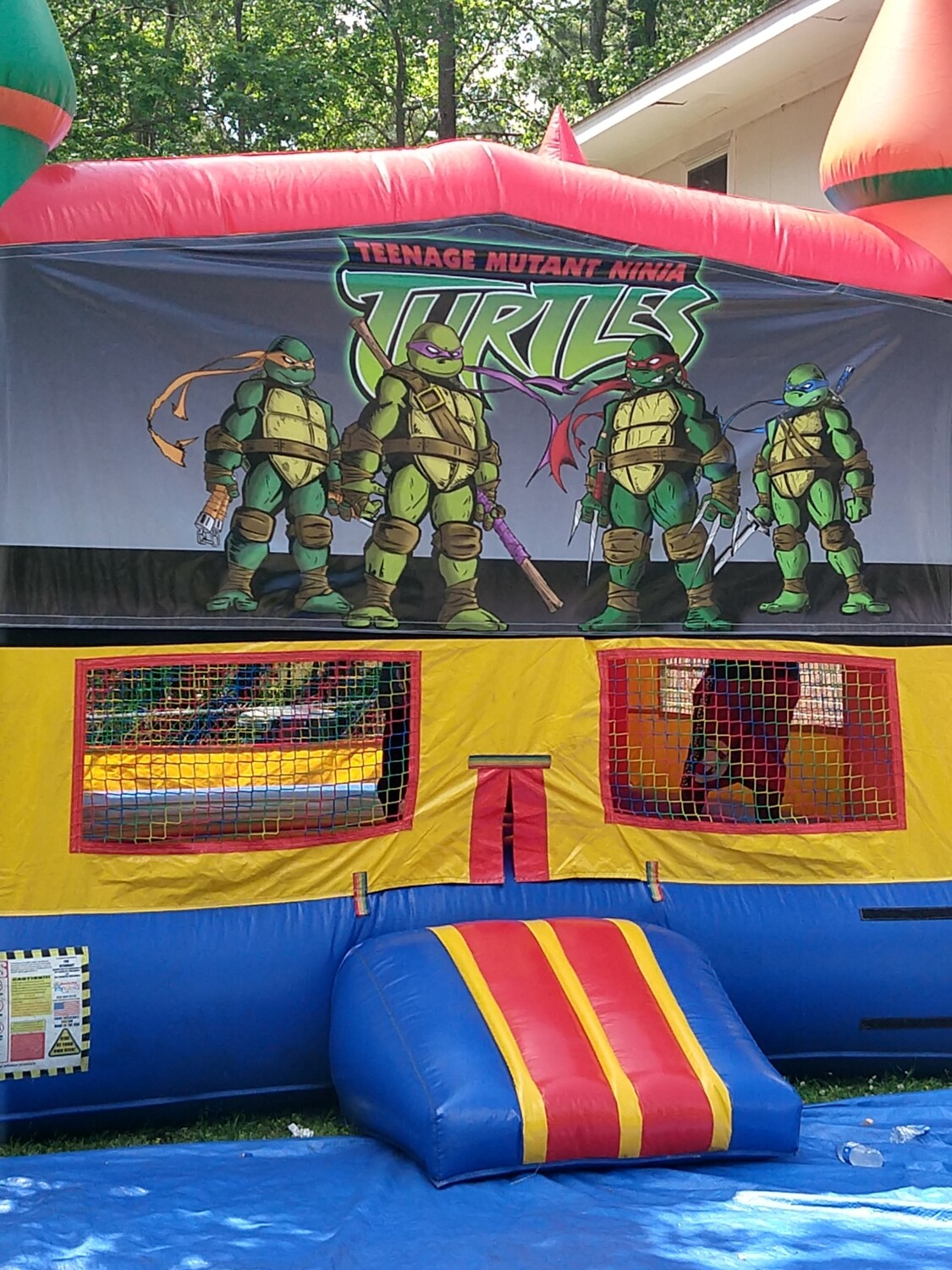 Ninja turtles jumping castle with basketball hoop inside.