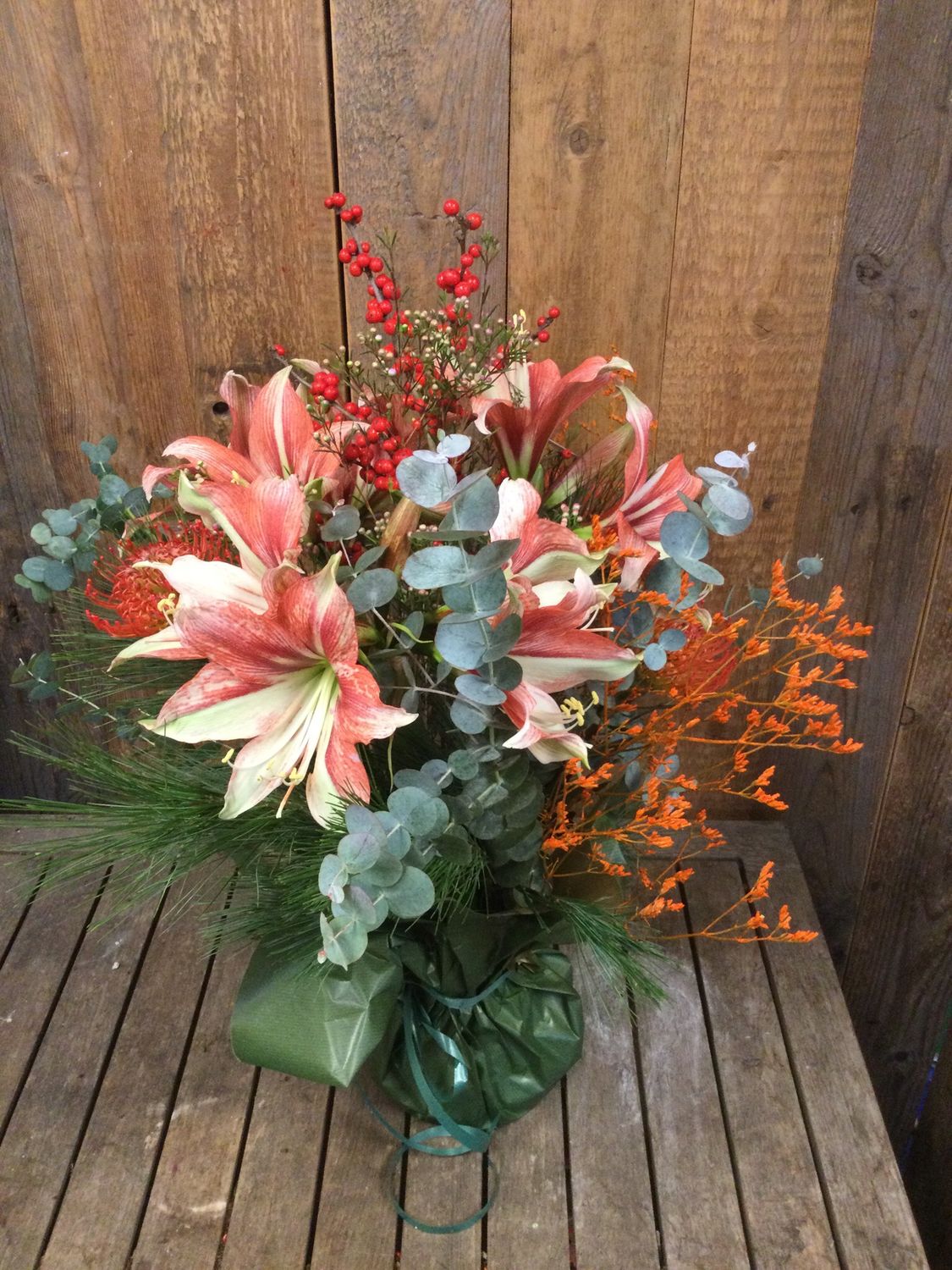 Kerstboeket met amaryllis en bessen oranje/rood