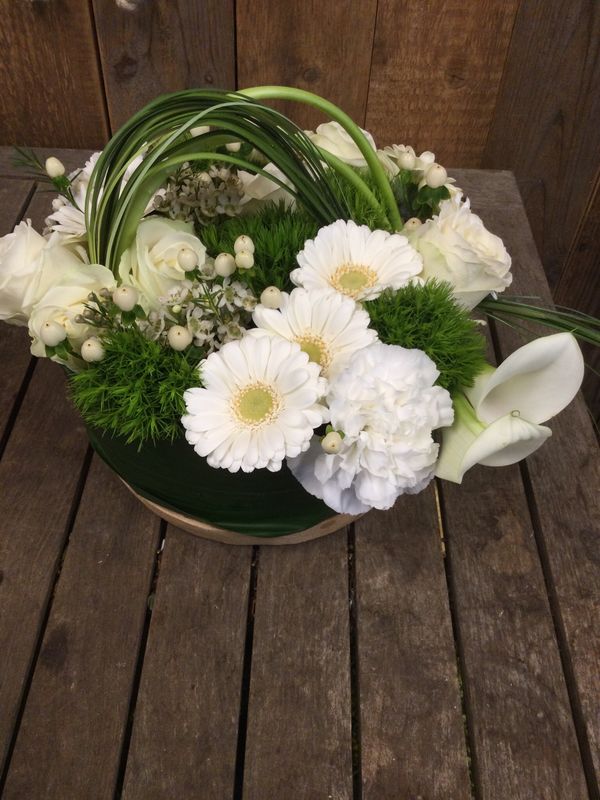 Rond bloemstuk op houten bord