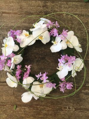 Krans voor rond een urne met witte en roze orchideeen