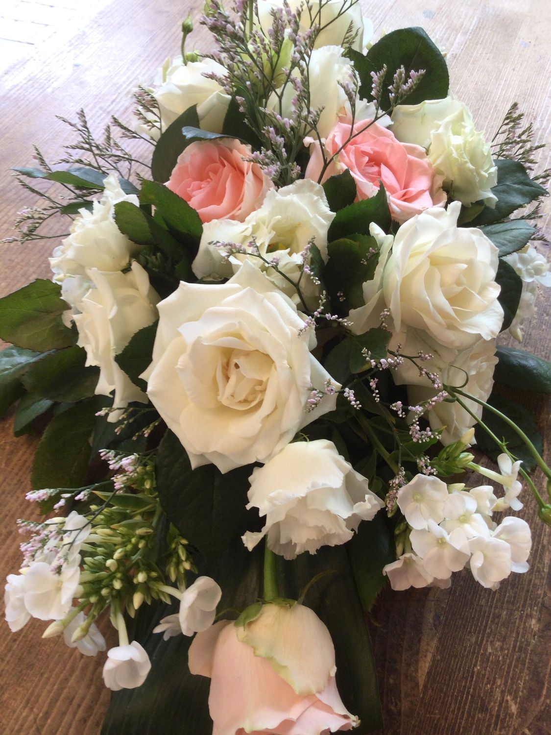 Klein grafstuk met roze en witte rozen