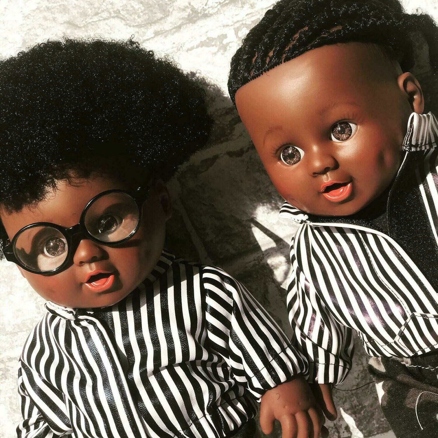 Reuben Doll- Afro hair
wearing Faux leather stripe jacket & clear circle glasses