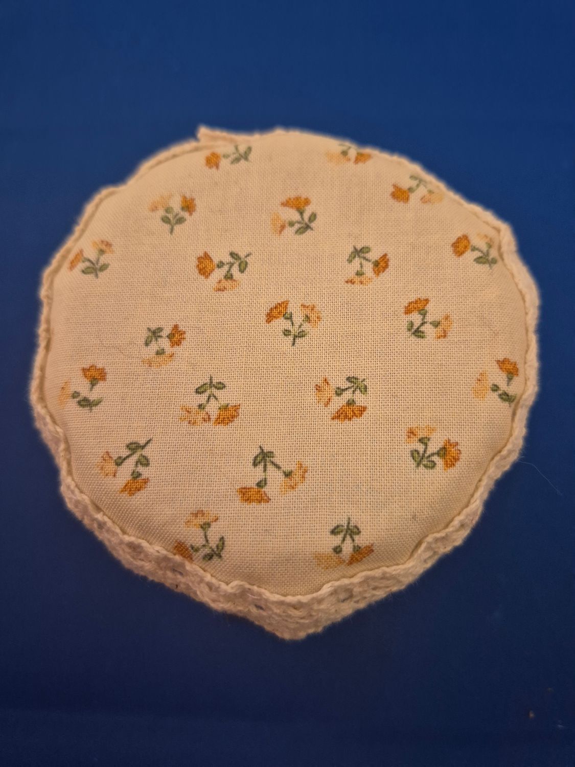 Small orange flowers on cream background beaded drinks cover