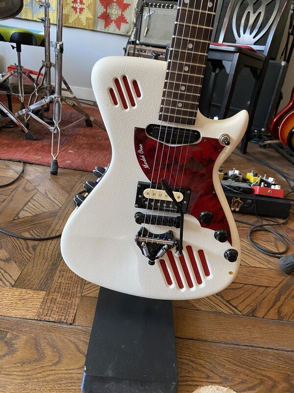 Cool White Dillo with tremolo and red accents.  Roasted neck.
