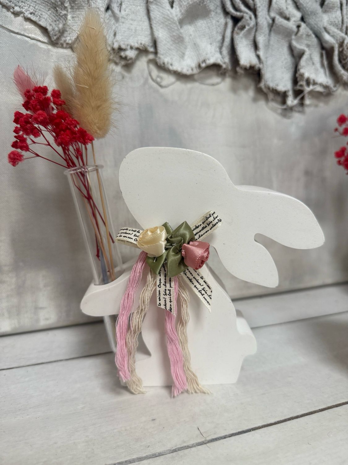 Osterhase mit Reagenzglas und getrockneten Blüten